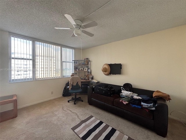 office space featuring light carpet, ceiling fan, and a textured ceiling