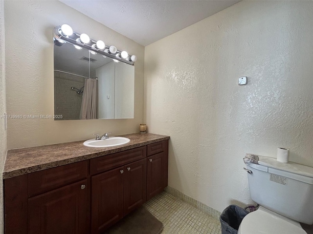 bathroom featuring tile patterned flooring, vanity, curtained shower, and toilet