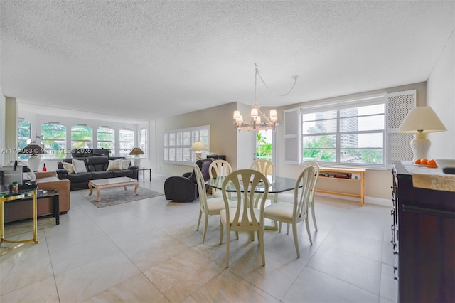 dining space featuring a textured ceiling, baseboards, and an inviting chandelier