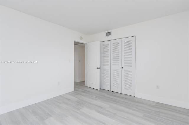 unfurnished bedroom featuring a closet and light wood-type flooring