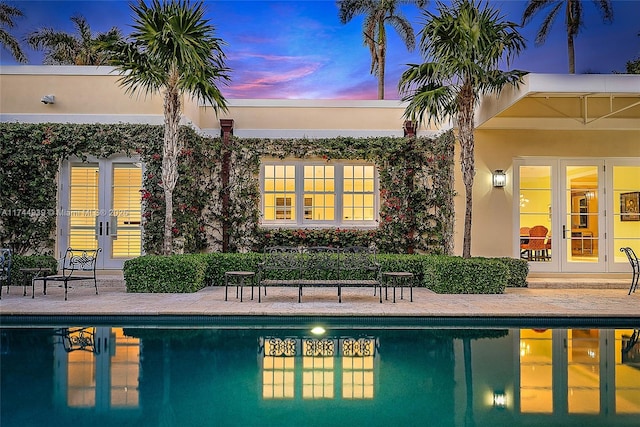 pool at dusk with french doors