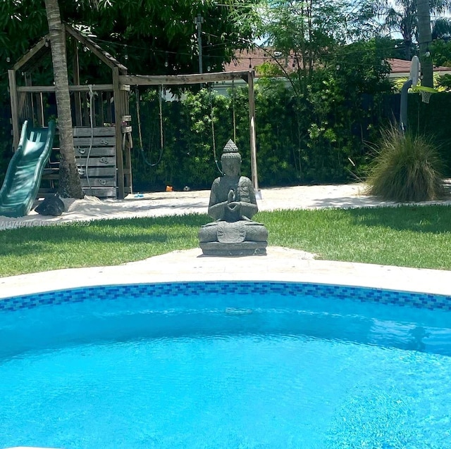 view of swimming pool with a playground