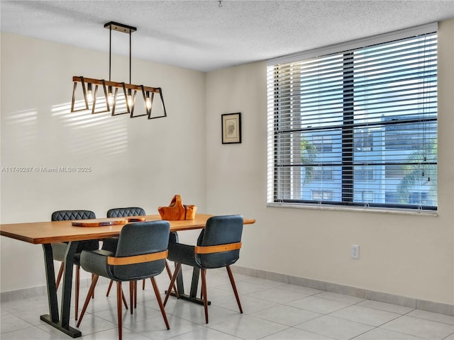 dining room featuring a textured ceiling and light tile patterned floors