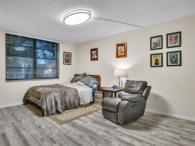 bedroom with light hardwood / wood-style flooring and a textured ceiling