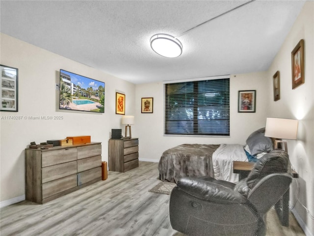 bedroom with light hardwood / wood-style flooring and a textured ceiling