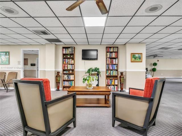 sitting room featuring ceiling fan, a paneled ceiling, and carpet floors