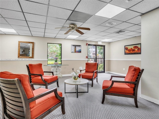 carpeted living room with a paneled ceiling and ceiling fan