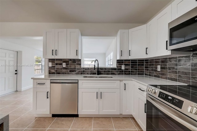 kitchen featuring white cabinetry, appliances with stainless steel finishes, sink, and decorative backsplash