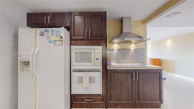 kitchen with dark brown cabinetry, wall chimney range hood, white appliances, and decorative backsplash