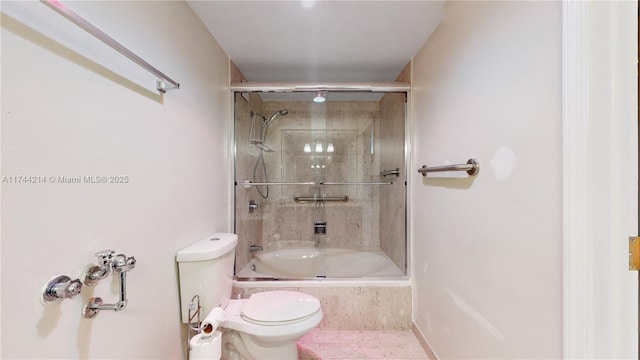 bathroom with bath / shower combo with glass door and toilet