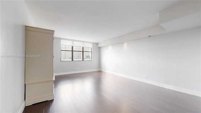 unfurnished room with dark hardwood / wood-style flooring