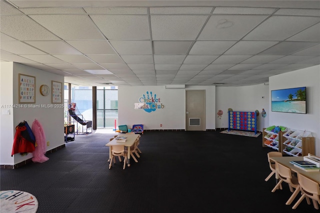 recreation room featuring a paneled ceiling and expansive windows