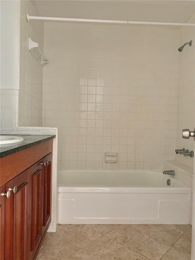 bathroom featuring vanity, tiled shower / bath combo, and tile patterned flooring