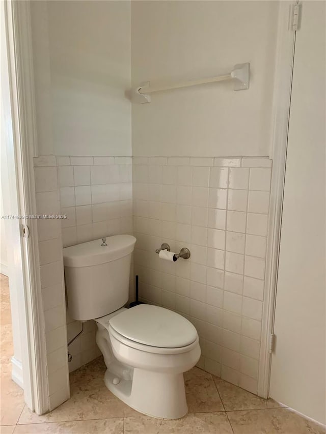 bathroom with tile walls, tile patterned floors, and toilet