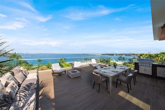 wooden deck featuring a water view, grilling area, and an outdoor hangout area