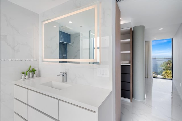 bathroom featuring tile walls, vanity, and walk in shower