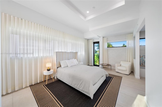 tiled bedroom with a tray ceiling