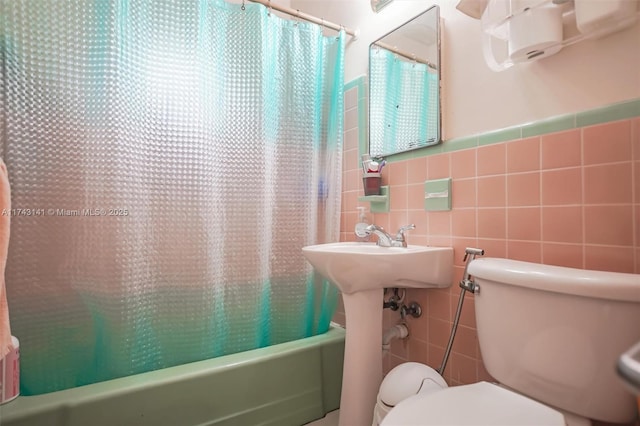 bathroom with tile walls, toilet, and shower / bathtub combination with curtain