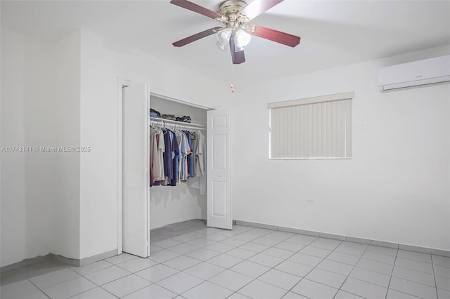 unfurnished bedroom featuring light tile patterned flooring, an AC wall unit, and a closet