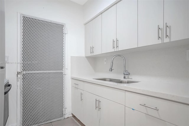 kitchen featuring sink, white cabinets, and light tile patterned flooring