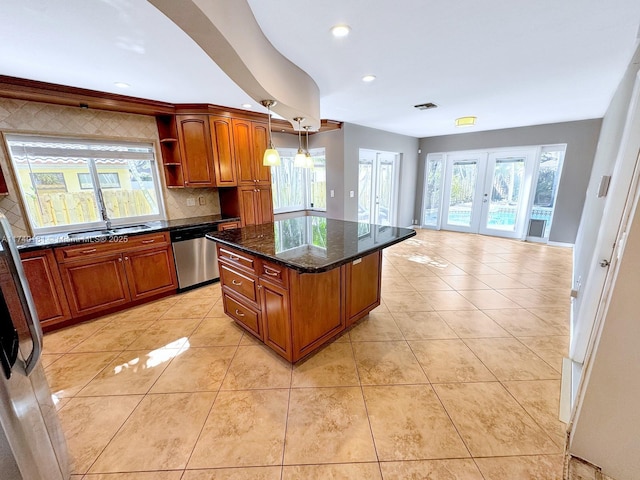 kitchen with a kitchen island, appliances with stainless steel finishes, pendant lighting, dark stone counters, and french doors