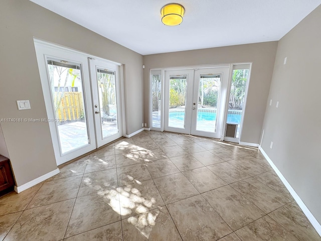 doorway to outside with a wealth of natural light, light tile patterned floors, and french doors