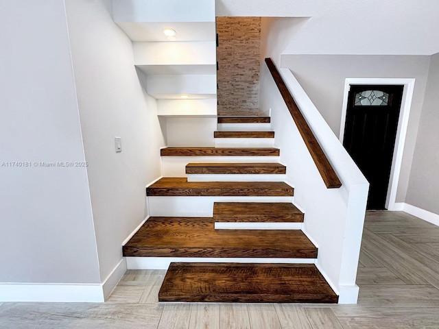 stairs featuring parquet flooring