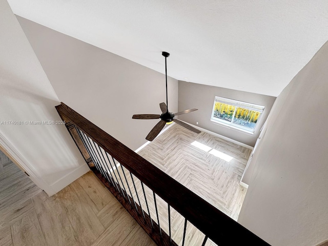 stairs featuring hardwood / wood-style flooring, vaulted ceiling, and ceiling fan