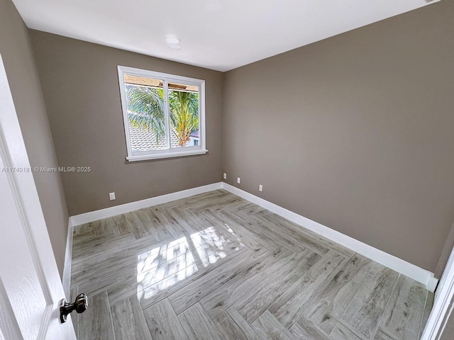 unfurnished room with light parquet flooring