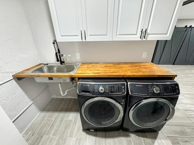 laundry area featuring cabinets, sink, and washer and dryer