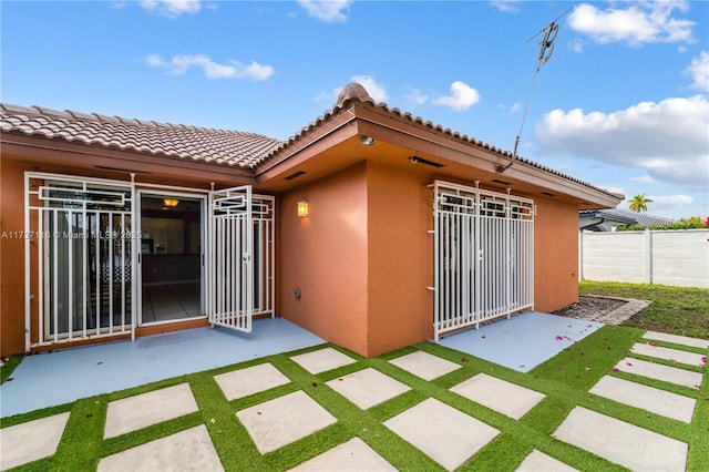 exterior space with a patio, fence, and stucco siding