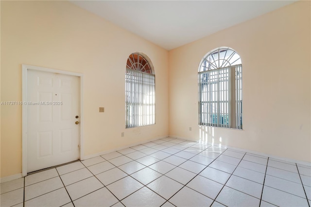 unfurnished room with light tile patterned floors and baseboards