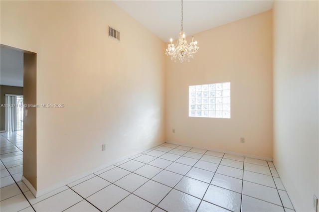 spare room featuring visible vents, plenty of natural light, an inviting chandelier, and light tile patterned floors