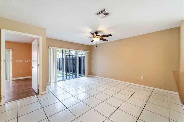 unfurnished room featuring light tile patterned floors, baseboards, visible vents, and a ceiling fan