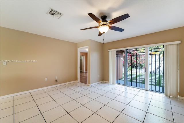 empty room featuring baseboards, visible vents, a ceiling fan, and light tile patterned flooring