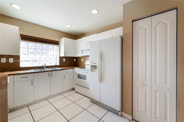 kitchen featuring recessed lighting, decorative backsplash, white cabinetry, a sink, and white appliances