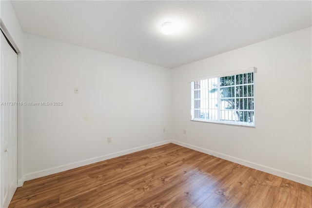 unfurnished bedroom with a closet, baseboards, and wood finished floors