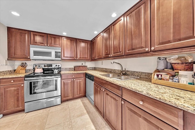 kitchen featuring light stone counters, stainless steel appliances, light tile patterned flooring, and sink