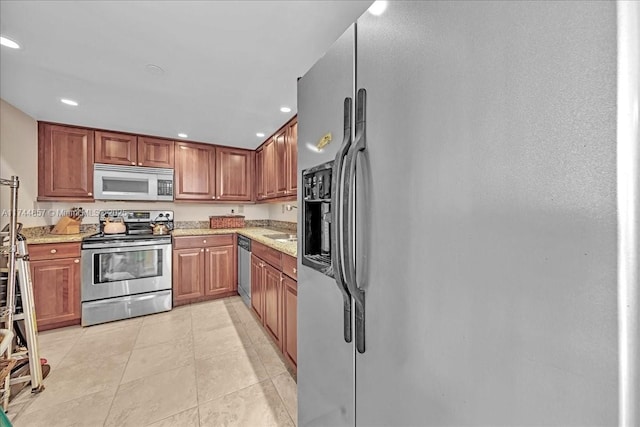 kitchen featuring stainless steel appliances, light stone countertops, sink, and light tile patterned floors