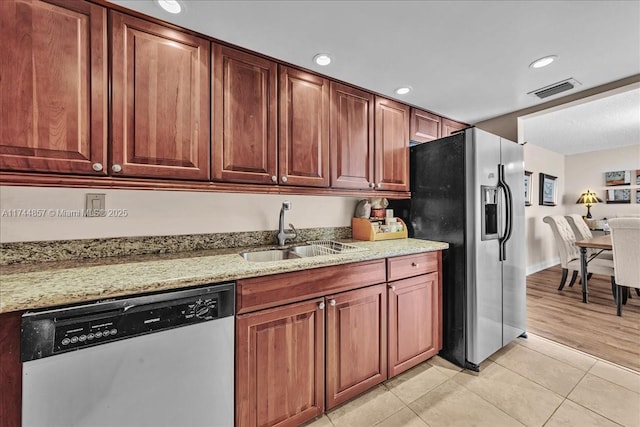 kitchen featuring light stone countertops, appliances with stainless steel finishes, sink, and light tile patterned flooring