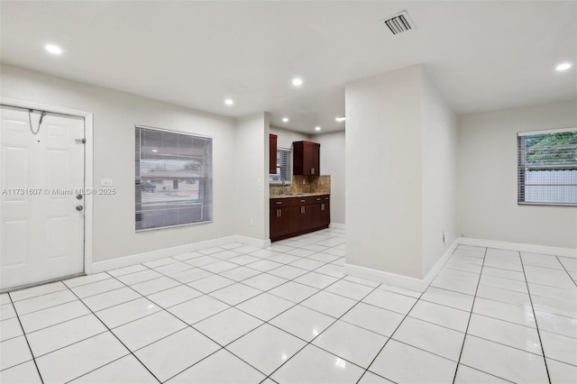 interior space featuring sink, light tile patterned floors, and backsplash