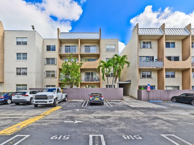 view of property with fence and uncovered parking