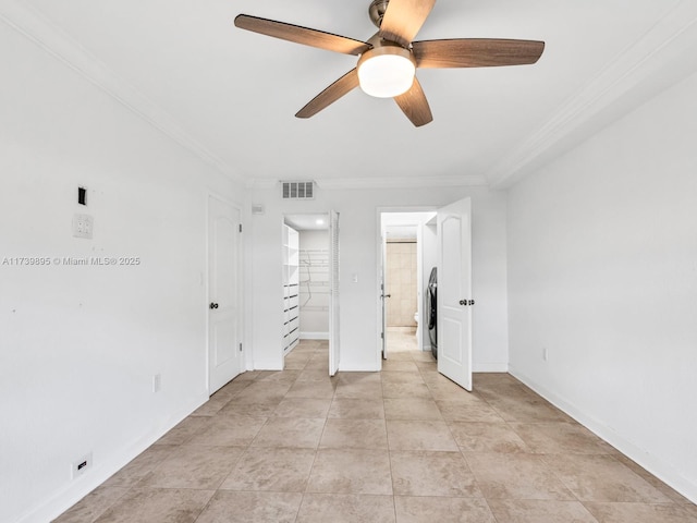 unfurnished bedroom with baseboards, visible vents, stacked washer and clothes dryer, ensuite bathroom, and crown molding