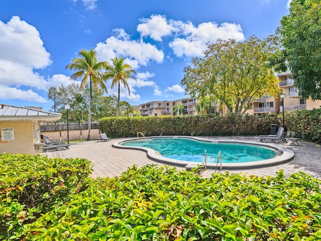 pool with a patio area and fence