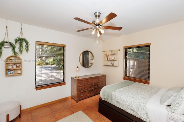 bedroom with multiple windows, baseboards, a ceiling fan, and light tile patterned flooring