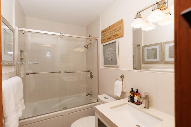 bathroom featuring bath / shower combo with glass door, vanity, and toilet