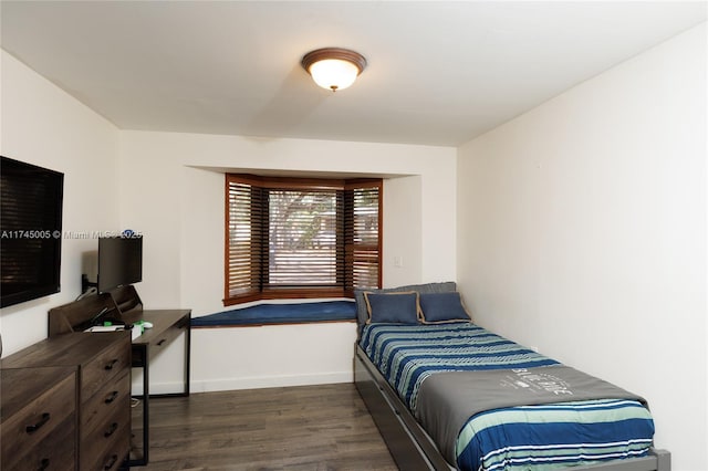 bedroom featuring dark wood finished floors and baseboards