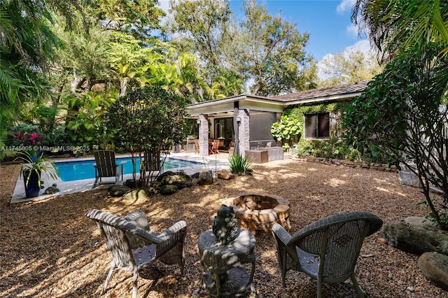 back of house with a patio, an outdoor fire pit, and an outdoor pool