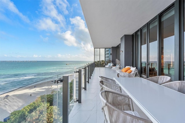 balcony featuring a water view and a view of the beach