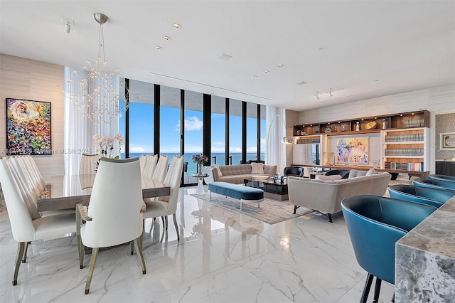 dining room with a water view, floor to ceiling windows, and an inviting chandelier